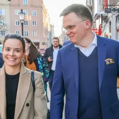 Aleksandra z uśmiechem idzie ulicą, obok niej jej mąż.