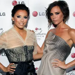 Eva Longoria i Victoria Beckham pozują do zdjęć, obie w eleganckich kreacjach. Ich uśmiechy i gesty sugerują radosne wags.