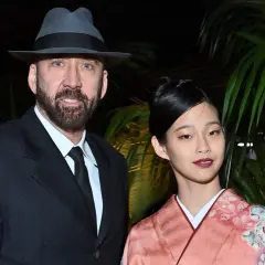 Nicolas Cage w kapeluszu i garniturze obok swojej żony w kimonie.
