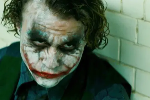 Heath Ledger jako Joker w jednym z jego niezapomnianych heath ledger filmy. Makijaż i spojrzenie budzą grozę.