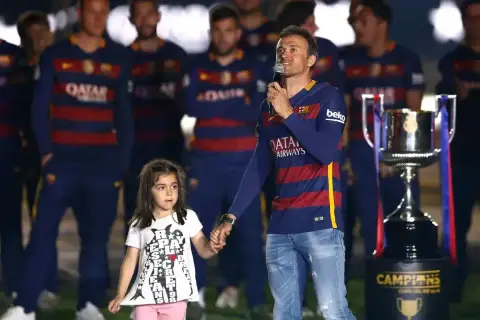 Luis Enrique z córką na scenie, obok pucharu.