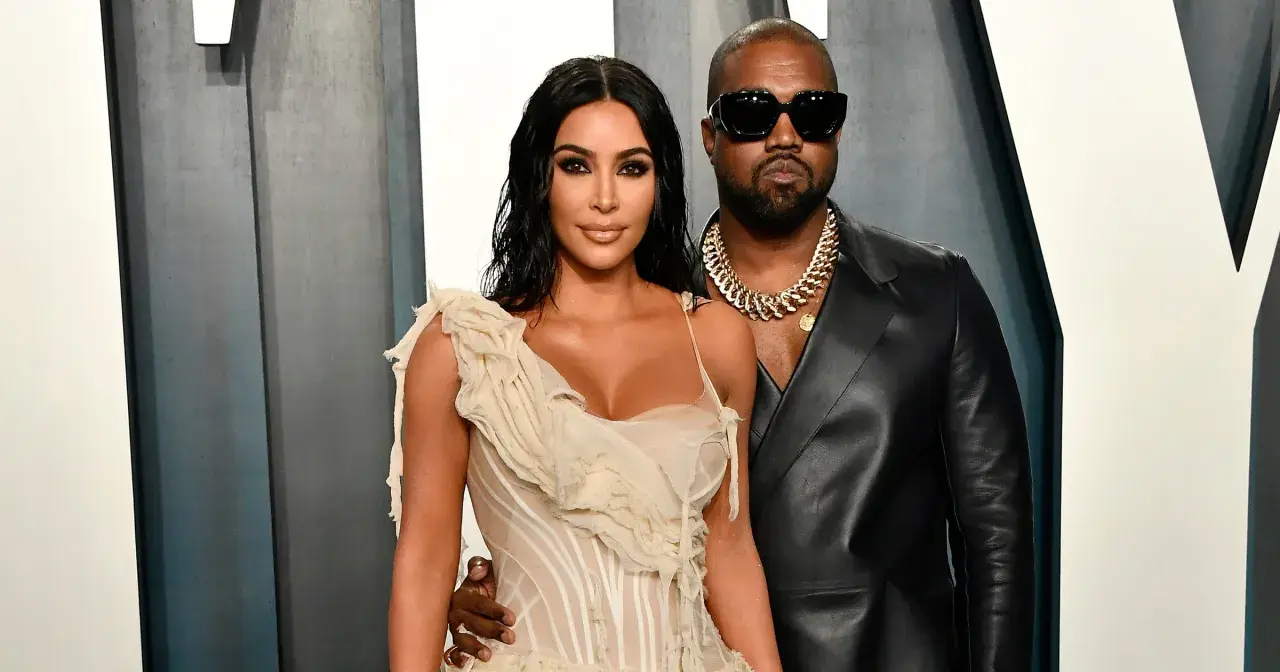 Kim Kardashian i jej mąż, Kanye West, pozują do zdjęć w eleganckich strojach.