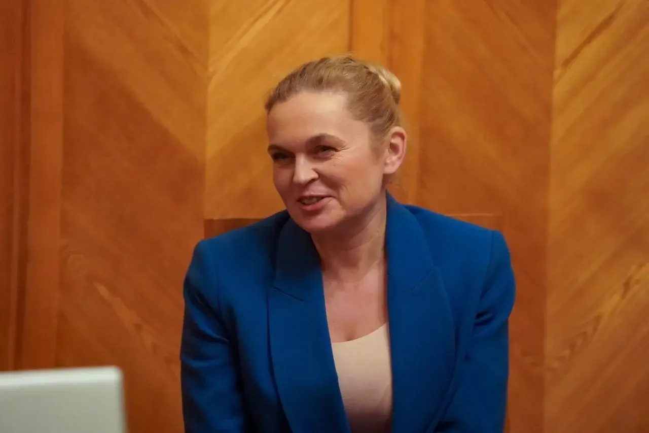 Barbara Nowacka w niebieskiej marynarce, rozmawiająca z Maciejem Rembarzem, partnerem Barbary Nowackiej.