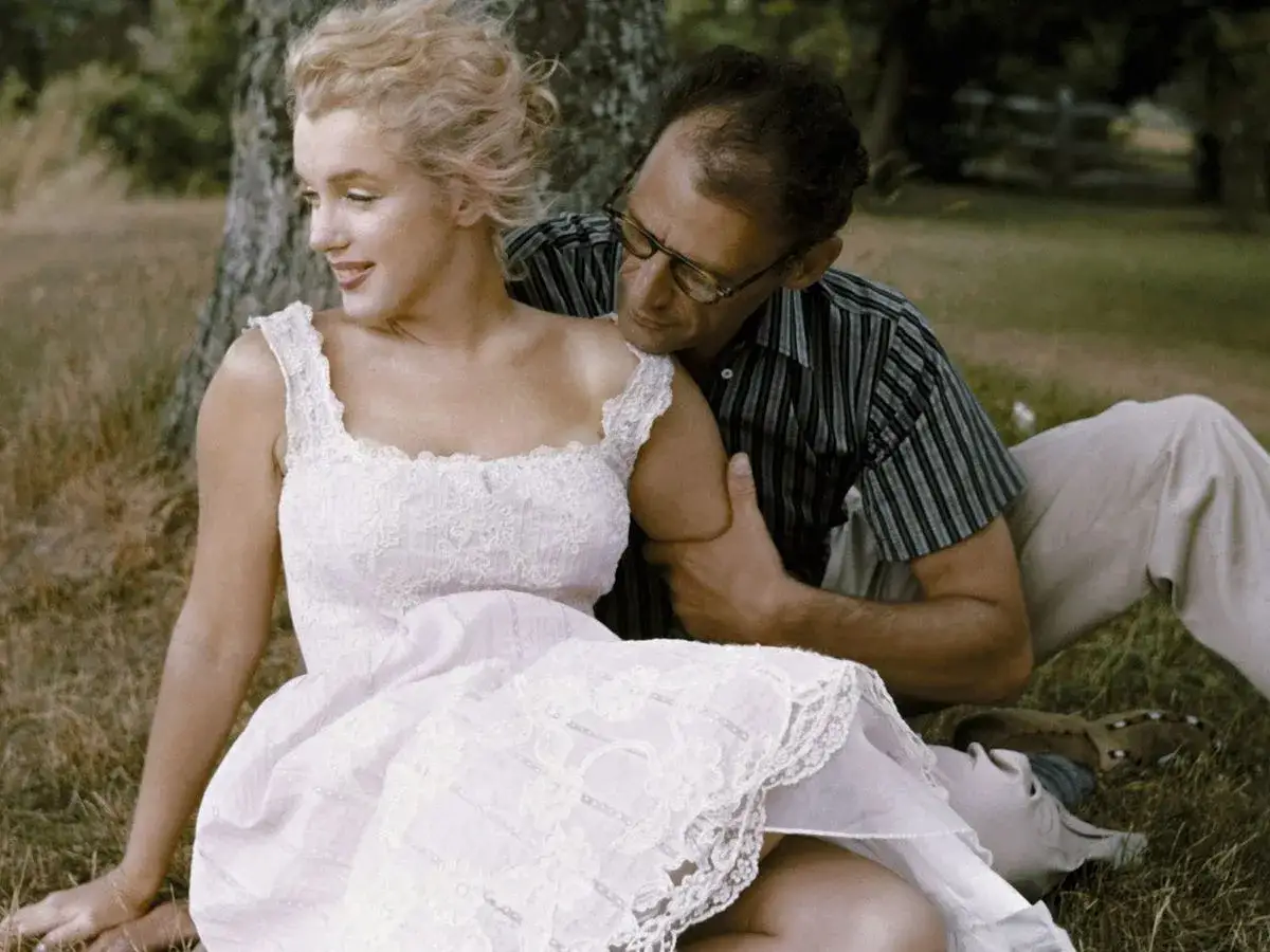 Marilyn Monroe w białej sukience, oparta o drzewo, z jej mężem Arthurem Millerem.