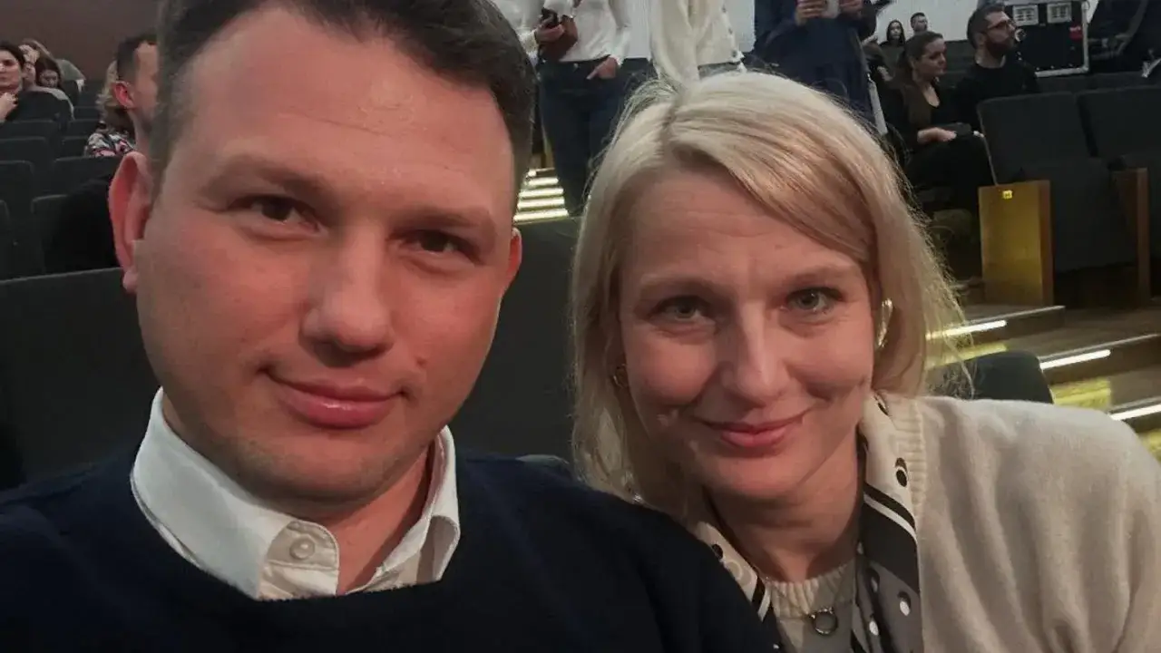 Sławomir Mentzen z żoną uśmiechają się do zdjęcia, siedząc w sali kinowej.