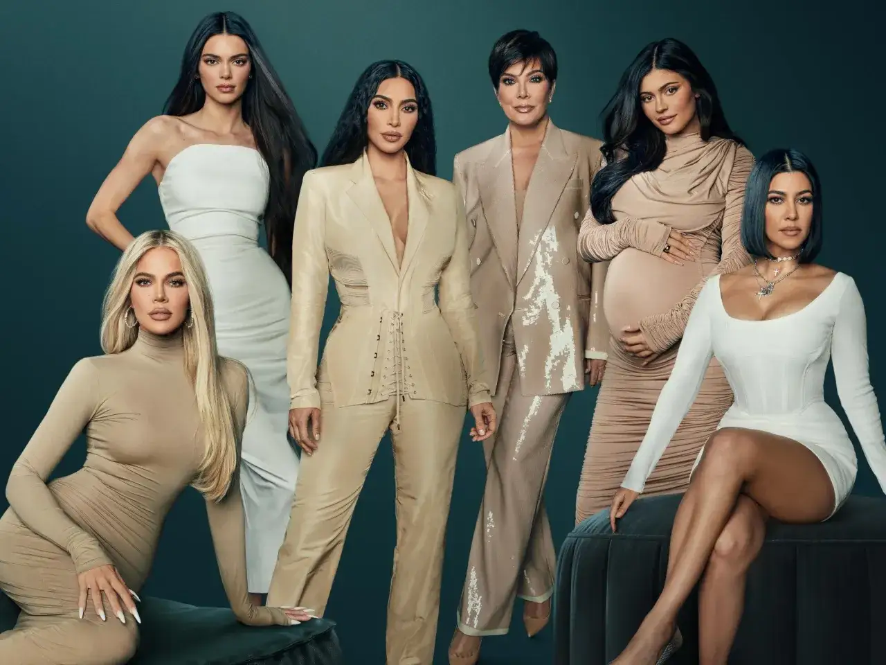 Kim Kardashian i jej siostry, całe rodzeństwo Kardashian-Jenner, pozują do zdjęcia w eleganckich, beżowych strojach.