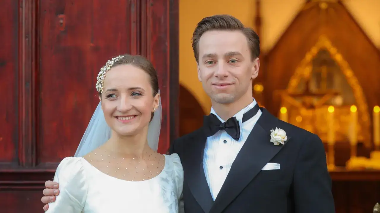 Krzysztof Bosak i jego żona w dniu ślubu, uśmiechnięci przed kościołem.